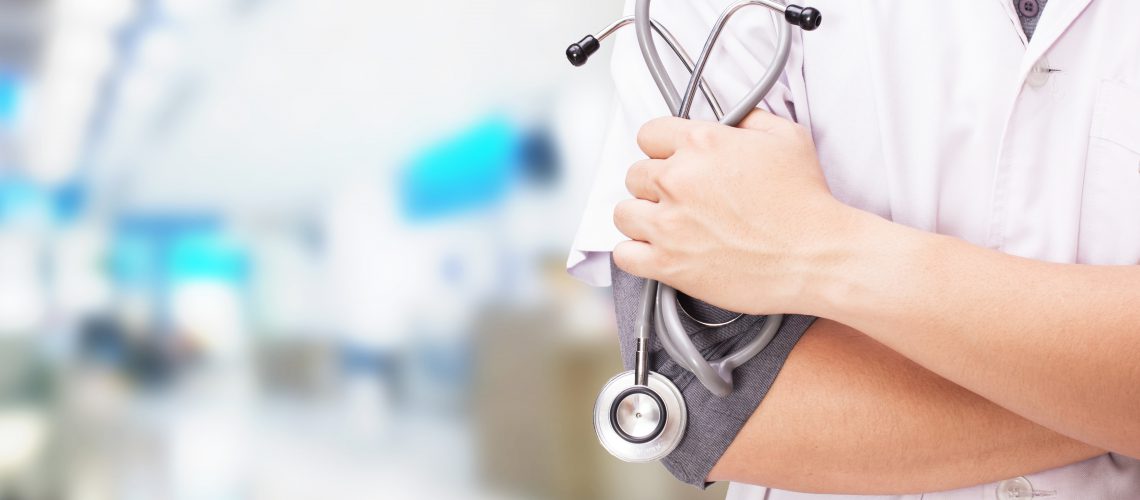 Doctor with stethoscope in hands and hospital background